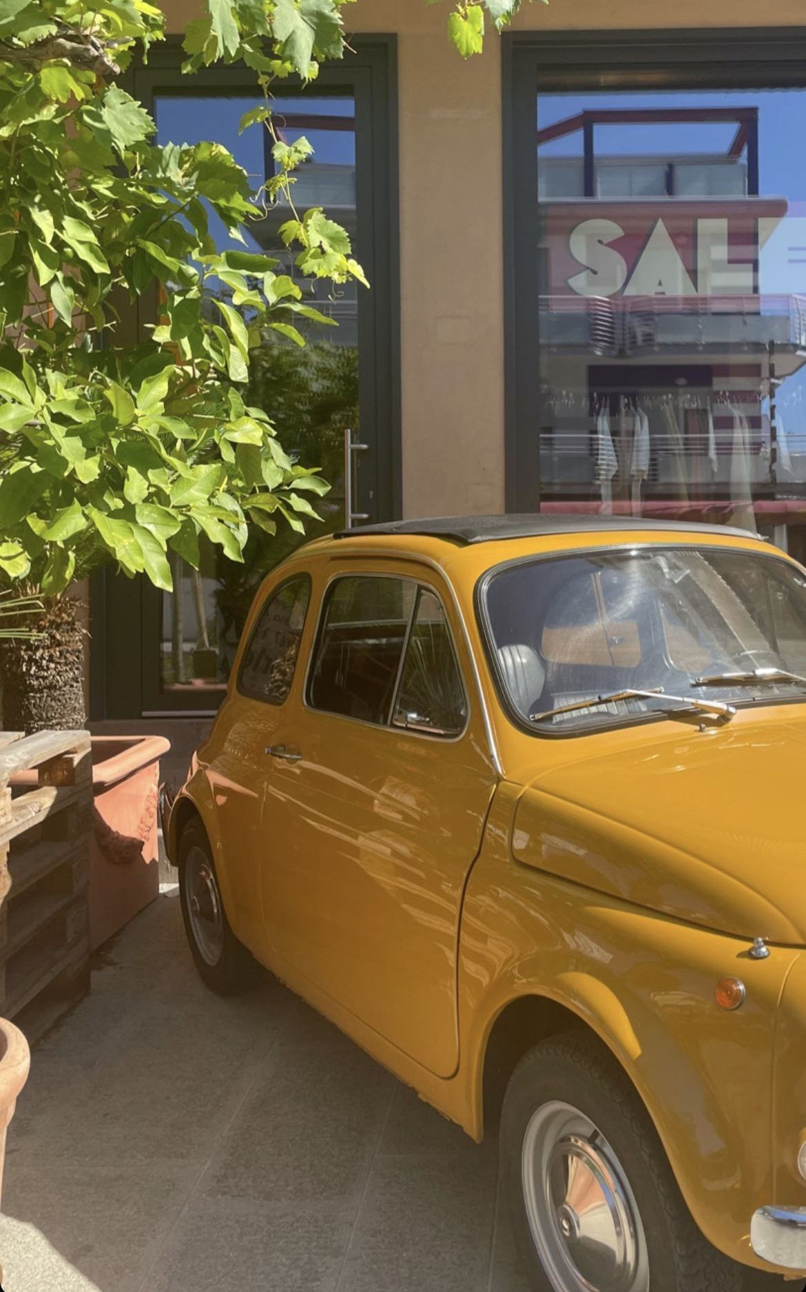 Picture of a Yellow Car infront of a Store